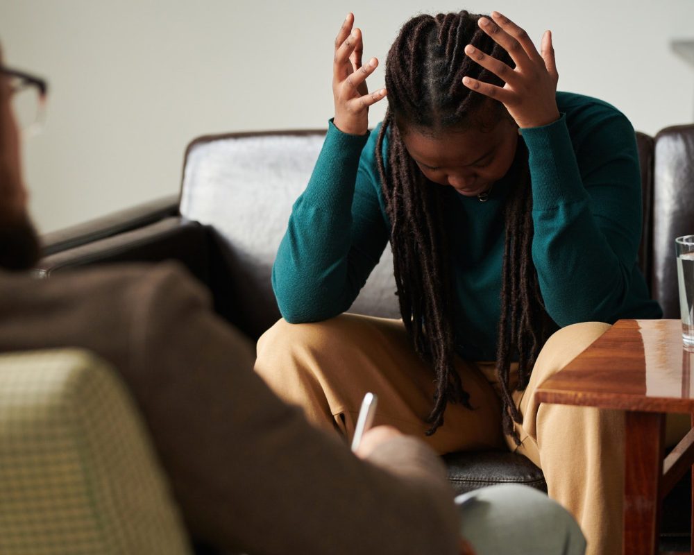 Patient expressing her anger sitting at psychotherapy